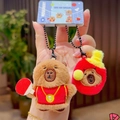 Detail of plush Capybara keychains wearing red jersey with table tennis racket - Ping Pong Pair