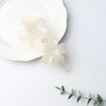 Creamy white double flower hair clip with a matte finish on a white textured plate - Ivory