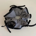 Détail d'un chouchou en tissu à carreaux noir et blanc avec un nœud en ruban élégant - Style à Nœud à Carreaux Noir