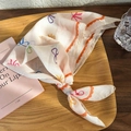Detail of floral linen headscarf with colorful bow patterns and orange wavy edges - Orange Bow (25218D)