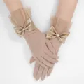 Detalle de guantes de tul champán con puños de volantes y lazos de satén suaves - Talla única / Color Piel