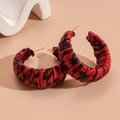 Detalle de pendientes de aro en C de cuero trenzado con estampado de leopardo rojo - Rojo
