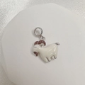 Macro detail of a white enamel sheep charm with silver loop on a white silk background - Style E (Goat)