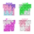 Set of four gift box shaped Pop It fidget toys in vibrant rainbow silicone colors - Gift Box Pop