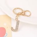 Close-up of golden letter J keychain with clear rhinestones and lobster clasp - Letter J
