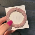 Close-up of pink faceted crystal beads on an elastic hair tie displayed on a white card - Pink