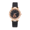Macro view of starry black watch dial with rose gold Love lettering and crystal accents - Black