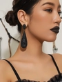 Luxurious long black teardrop earrings with shimmering rhinestones on a female model - Extreme Black