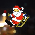 Christmas window sticker featuring Santa Claus in a red sleigh with gold glitter accents - Santa Claus Sled