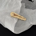 Close-up of golden irregular wave edge metal hair clip with polished finish - Gold Irregular Surface Style