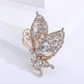 Macro detail of butterfly brooch featuring sparkling rhinestones and a pearl drop - White