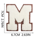 Macro detail of 7cm chenille letter M patch with white embroidery and coffee brown borders - Letter M
