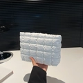 White quilted bubble texture clutch bag held by hand made of soft PU leather - White