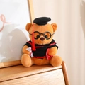 Close-up of a brown teddy bear in a black graduation gown with a scroll and red book - 20cm / Brown