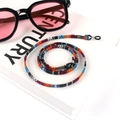 Close-up of bohemian woven cotton eyewear strap with adjustable rubber loops on book - Size 16