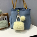 Detail of light blue denim mini bag keychain with faux fur pendant and pearl accents - Light Yellow