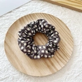 Black scrunchie with white daisy floral pattern on a minimalist wooden tray - Coffee Floral