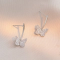 Silver color butterfly drop earrings with micro-pave zircons on a beige silk fabric background - Silver Pave Butterfly Style (E0464)