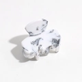 Detail view of stylish leopard marble pattern hair claw clip with silver spring mechanism - Off-White