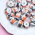 Detail of colorful hand-painted glass beads with textures on a white ceramic plate - White Bead Black Orange Cream