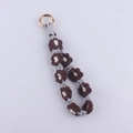 Close-up of handmade woven daisy keychain with brown cotton flower and gold metal clip - Coffee