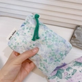 Close-up of floral cotton coin purse with green zipper pull and simple wish label - Green Purple Floral