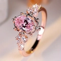 Vista macro de un elegante anillo de oro rosa con una gran gema ovalada rosa y circonitas - Talla 6 / Rosa oro