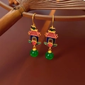 Detail of traditional palace lantern earrings with gold filigree and green beads on bamboo - S925 Silver Pin Gold Green Heart Lantern Style