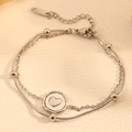 Close-up van dubbellaagse zilveren titaniumstalen armband met hart hanger en kralen - Dubbellaagse Slangenketting met Hart Ronde Tag (I115) / Zilveren Hart Armband