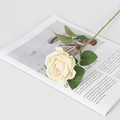 Single stem cream artificial velvet rose with green leaves on white tabletop - Small Velvet Champagne