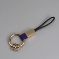 Porte-clés créatif avec anneau en métal doré, cordon noir tressé et cuir violet - Violet + Or