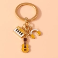 Detailansicht des Schlüsselanhängers mit Emaille-Anhängern für Klavier, Kopfhörer und Gitarre - Gelb