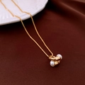Dettaglio collana a maglia veneziana placcata oro 18k con perle su tessuto marrone - Oro