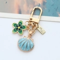 Goldener Legierung-Schlüsselanhänger mit blauer Muschel und grüner Blume für Taschen - Blaue Muschel