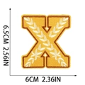Detail of embroidered letter X patch with wheat pattern and dimensions 6.5cm x 6cm - Letter X