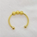 Nahaufnahme eines goldfarbenen, offenen Fidget-Rings mit drei rotierenden Perlen. - Einheitsgröße / Drei-Perlen-Stil / Gold