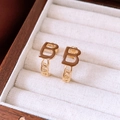 Detailoverzicht van goudkleurige kettingoorbellen met bruine B-letter emaille bedeltjes - Zilveren Oorknopje - Goud & Koffie (Echt Goud Verguld)