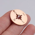 Makroaufnahme von Kompass-Anhänger in Roségold mit hohlem Stern-Design und NESW-Gravur - Roségold