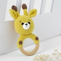 Detail of handmade knitted giraffe baby rattle toy with natural wooden ring handle - Orange and Yellow Deer