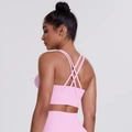 Detail of pink sports bra featuring cross-back straps and soft brushed elastic fabric - Sakura Pink