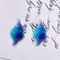 Dettaglio macro di ciondoli a conchiglia in resina sfumata blu-viola glitterata per fai-da-te - Stile Conchiglia Cangiante