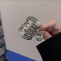 Detalle de pinza para el pelo en espiral plateada con diseño de metal multicapa - Línea Coleta Alta / Plateado