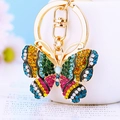 Detailed macro view of gold butterfly keychain with vibrant colorful rhinestones - Camouflage Green Yellow Butterfly