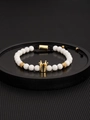Close-up of a white bead crown bracelet with black braided cord and gold-tone details - Gold Crown With White Stone