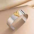 Polished silver C-shape steel bangle with a 3D gold heart in a minimalist style - Silver Body With Gold Heart (2018)