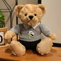 Light brown plush teddy bear wearing a grey panda hoodie and black trousers - Panda Holding Bamboo Hoodie Set / Gray