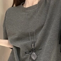 Detail of silver grid square pendant necklace with black ribbon bow on a grey tshirt - 25# Necklace - Silver - Black Bow Square Grid