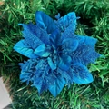 Macro shot of blue artificial Christmas flower with glitter on green pine needles - Lake Blue