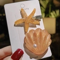 Detalle de pinzas para el pelo de estrella de mar ámbar con perlas en tarjeta artesana - Estrella de mar + Concha / Naranja