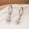 Detailed macro view of silver flower huggie earrings with sparkling zircon inlay - Four Petal Flower Silver Style (WG-0654)